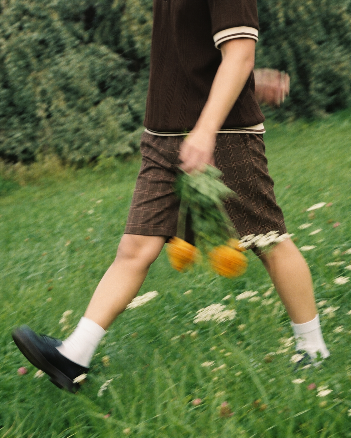 NAWK campaign look walking through a green field