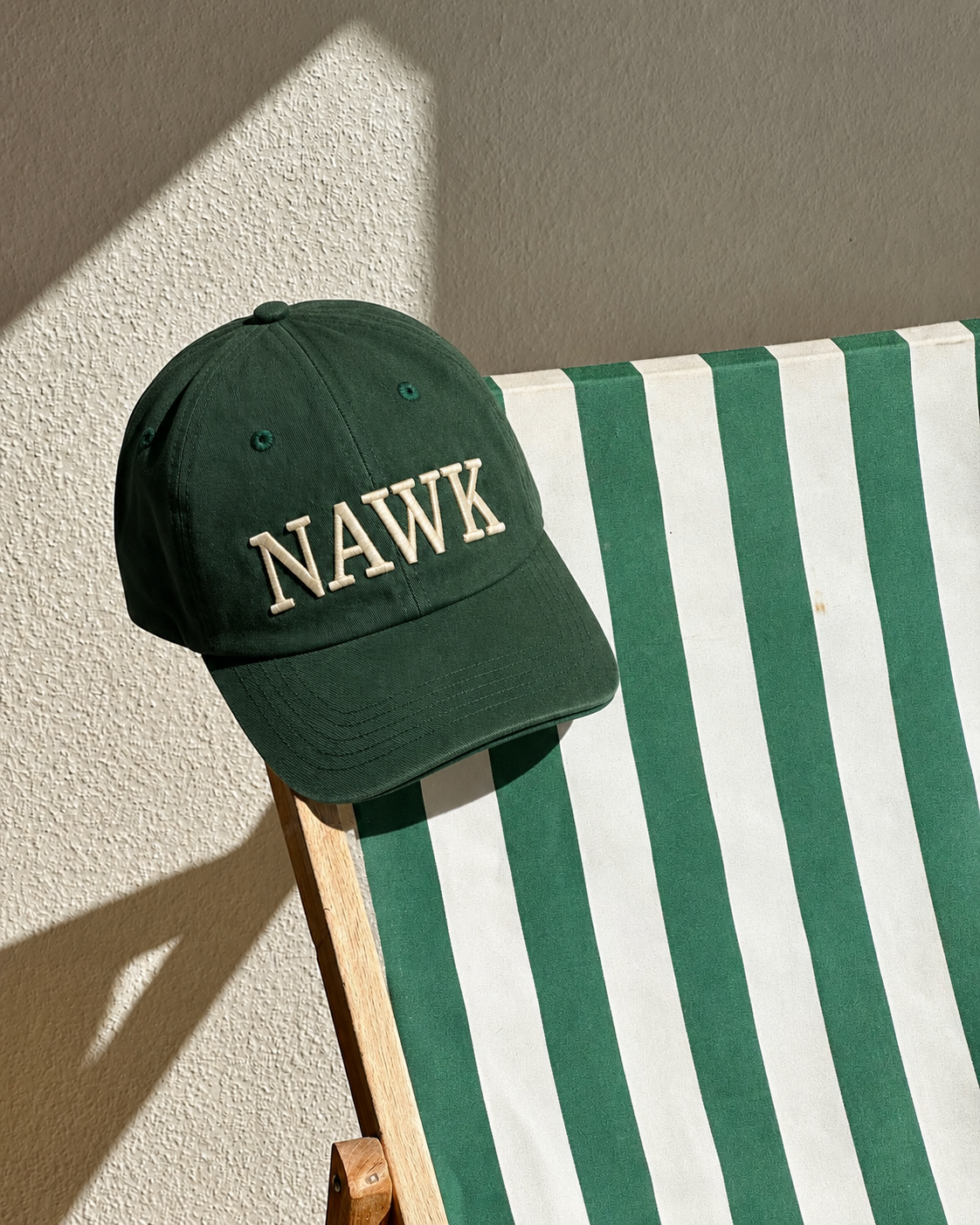 Green NAWK cap on a striped chair